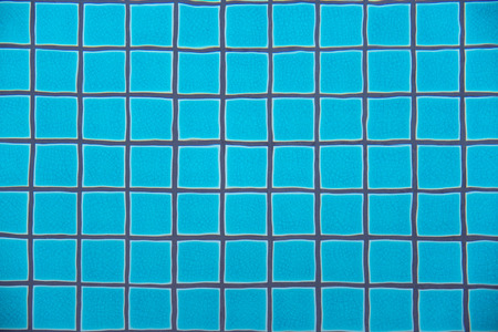 Swimming pool clear water showing turquoise blue clay square tiles and grey cement grout lines underwater wave copyspace background, Phuketの写真素材