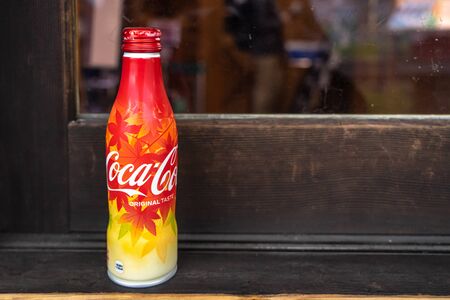Kyoto, Japan - November 12, 2018: Coca-cola metal bottle, special edition 2018 with autumn maple leaves print pattern in red, yellow and orange colors, front side, Kameokaのeditorial素材