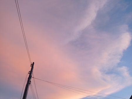 Silhouette of high voltage pole and sky with cloud at sunsetの写真素材