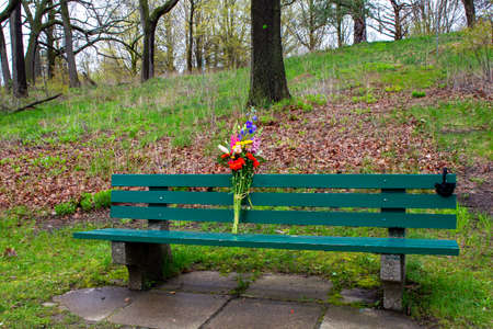 Green bench with bouquet of flowersの写真素材
