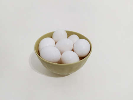 Many eggs, a bowl full of white eggs on a white backgroundの写真素材