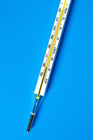 Mercury Thermometer with blue blackground showing degree on both F and Cの写真素材