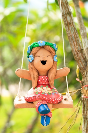 Happy Clay doll playing swing on sunny dayの写真素材