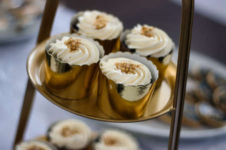Gold cream cupcakes on cake stand