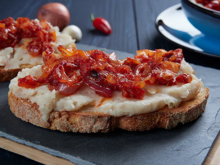Mashed beans spread with garlic vegetable oil, with a topping of sauteed onions and tomato paste (Romanian: fasole batuta), an all-time favorite during lent and other times of religious feastingの写真素材