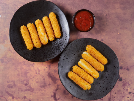 Oven baked mozzarella sticks, served with tomato sauceの写真素材