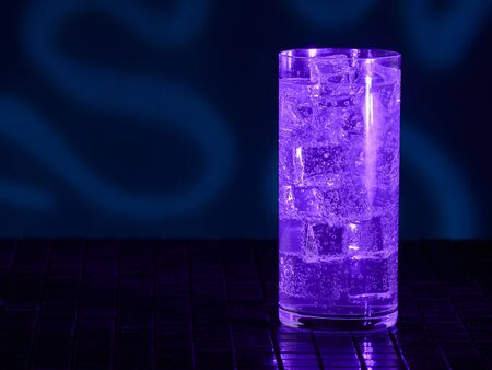 A glass of Mountain Dew under blacklight (UV) illumination. Glow in the dark drink.の写真素材