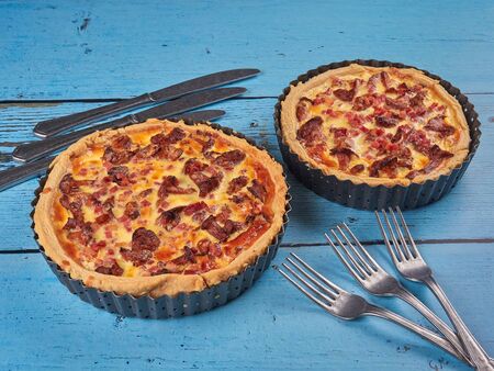 Homemade quiche with chanterelles and ham, on blue backgroundの写真素材