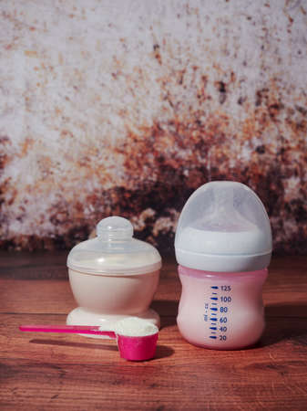 A bottle of organic milk formula for infants, on brown backgroundの写真素材