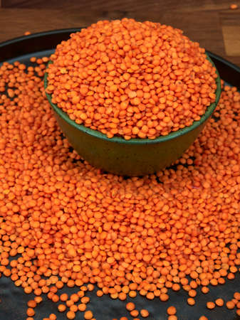 Red lentils, uncooked, in a green ceramic bowl