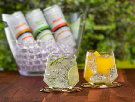 Hard seltzer with different flavors. A low-alcohol, sweet and fizzy drink, on garden backgroundの写真素材