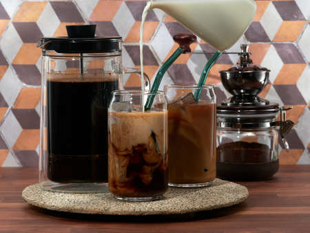 Making cold brew coffee with milk in a french press, also known as a cafetiÃ¨re, coffee press, or coffee plungerの写真素材