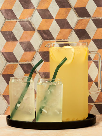A jug and two glasses of Elderflower cordial on a geometric pattern backgroundの写真素材