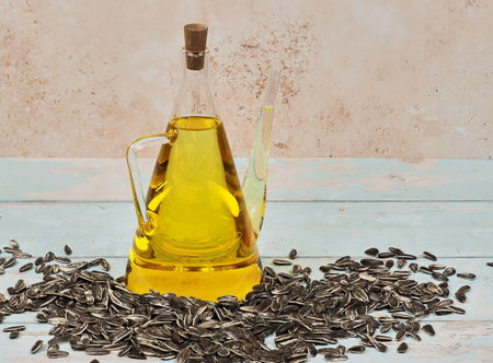 A jug of cold pressed sunflower oil on bright blue wooden backgroundの写真素材