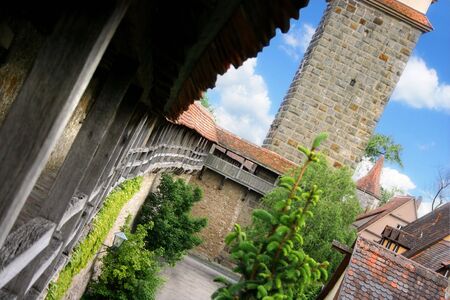 Dynamic view of a medieval city wall with old houses and clear blue sky.の写真素材