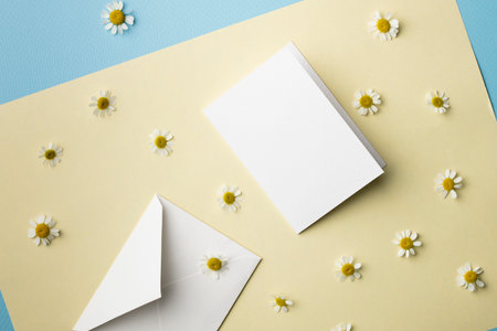 White greeting card and envelope mockup with white daisies on yellow background