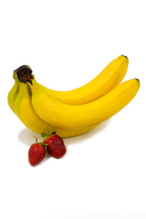 Isolated fruits bananas and strawberries. Two strawberries and a bunch of four bananas on a white backgroundの写真素材