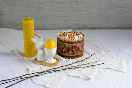 Easter card. Willow branches, a yellow wax candle, an Easter festive cake and a painted egg. Banner....