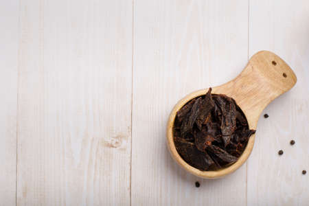 Jerky meat on a wooden background. Dried beef. rustic style. wooden dishes. copyspace. close up.