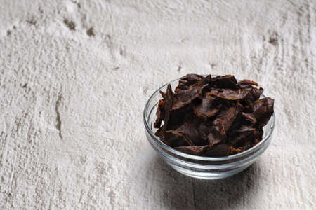 Jerky meat on a wooden background. Dried beef. rustic style. wooden dishes. copyspace. close up.