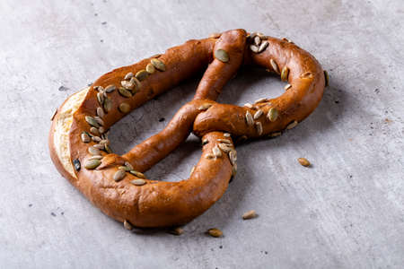 Bavarian pretzel with sunflower and pumpkin seeds on the table close-up