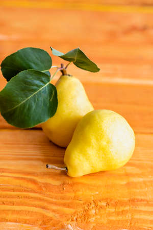 Two ripe yellow pears removed from the tree just now, two pears lying on a wooden table background close up, macroの写真素材