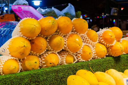 Exotic fresh Thai fruits at the night market in Pattaya Thailand: papaya and yellow mangoの写真素材