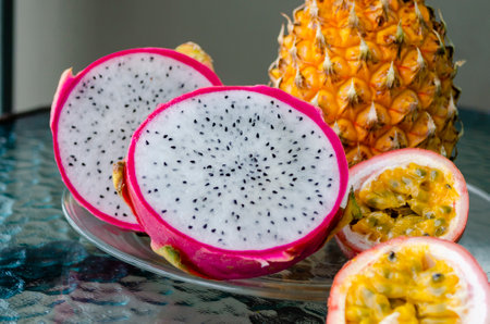 Cut in half passion fruit and dragon fruit close-up. Exotic tropical delicious Thai fruit passion...