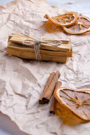 Natural incense for home scenting and meditation: palo santo sticks, cinnamon sticks and orange slices close-up with a focus on the palo santo bundleの写真素材