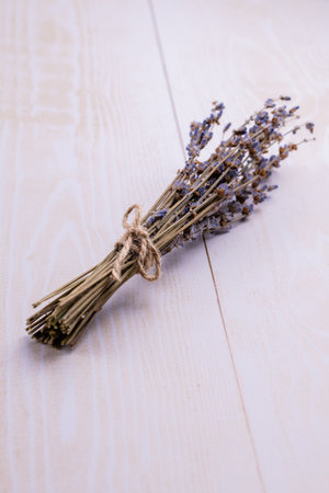 A bunch of dry lavender is a natural fragrance for the home on a light wooden background. close-up. copyspace.の写真素材