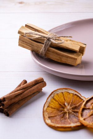 Natural incense for home scenting and meditation: palo santo sticks, cinnamon sticks and orange slices close-up with a focus on the palo santo bundleの写真素材