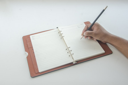 a man writing diary  on white tableのeditorial素材