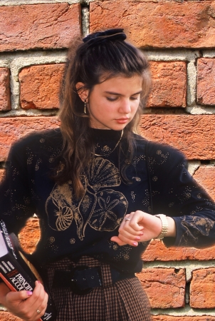 Young college student looking at her watchの写真素材