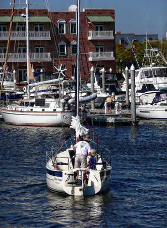 Sailboat with a person on board entering the harborのeditorial素材