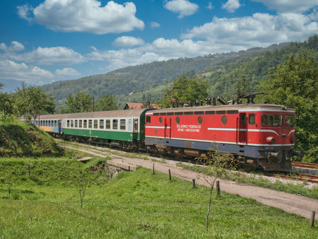 Diesel locomotive with a passenger car traveling through the Bosnia and Herzegovina countrysideのeditorial素材
