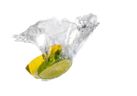 Lemon and limitice dropping in water and splashの写真素材