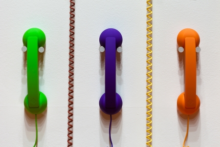 Phones on the wall with phone cordsの写真素材