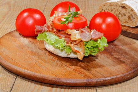 Toast, toast bread with bacon, ham garnished with tomatoes, lettuce and rosemaryの写真素材