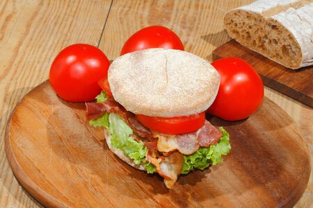 Toast, toast bread with bacon, ham garnished with tomatoes, lettuce and rosemaryの写真素材