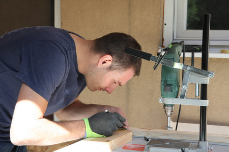 A man in the yard enjoys the processing of wood