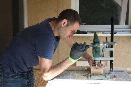 A man in the yard enjoys the processing of wood