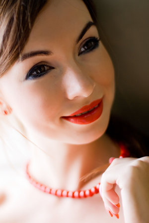 Closeup face portrait of the lady in red beadsの写真素材