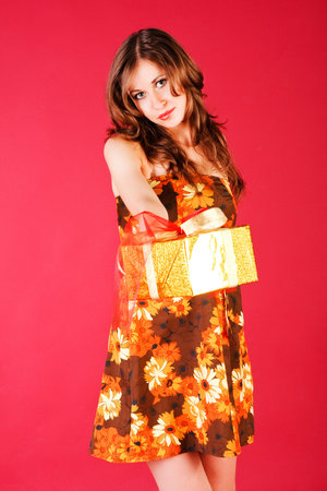 Picture of a beautiful adorable young girl in dress with a presentの写真素材