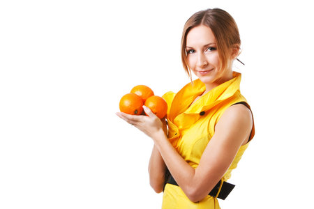 Picture of a young pretty girl in yellow dress which holds oranges. Isolated on white.の写真素材