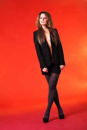 Picture of a beautiful young girl in jacket on orange backgroundの写真素材