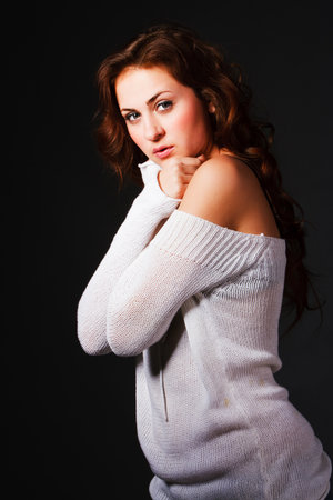 Portrait of a attractive young brunette in sweater on gray backgroundの写真素材