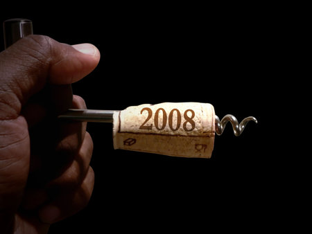 hand holding a cork screw just pulled from a bottle of wine to celebrate new years eveの写真素材