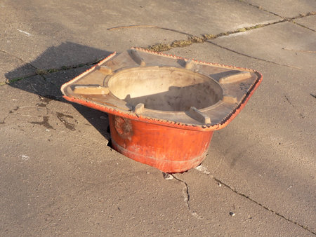 photo of a construction cone filling a pothole in a city sidewalkの写真素材