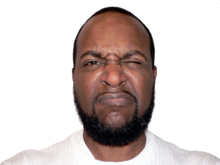 frown face shot of a African American male showcasing facial expression isolated on white backgroundの写真素材