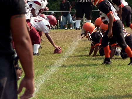 photo of little league football players of opposing teams facing off on the fieldの写真素材